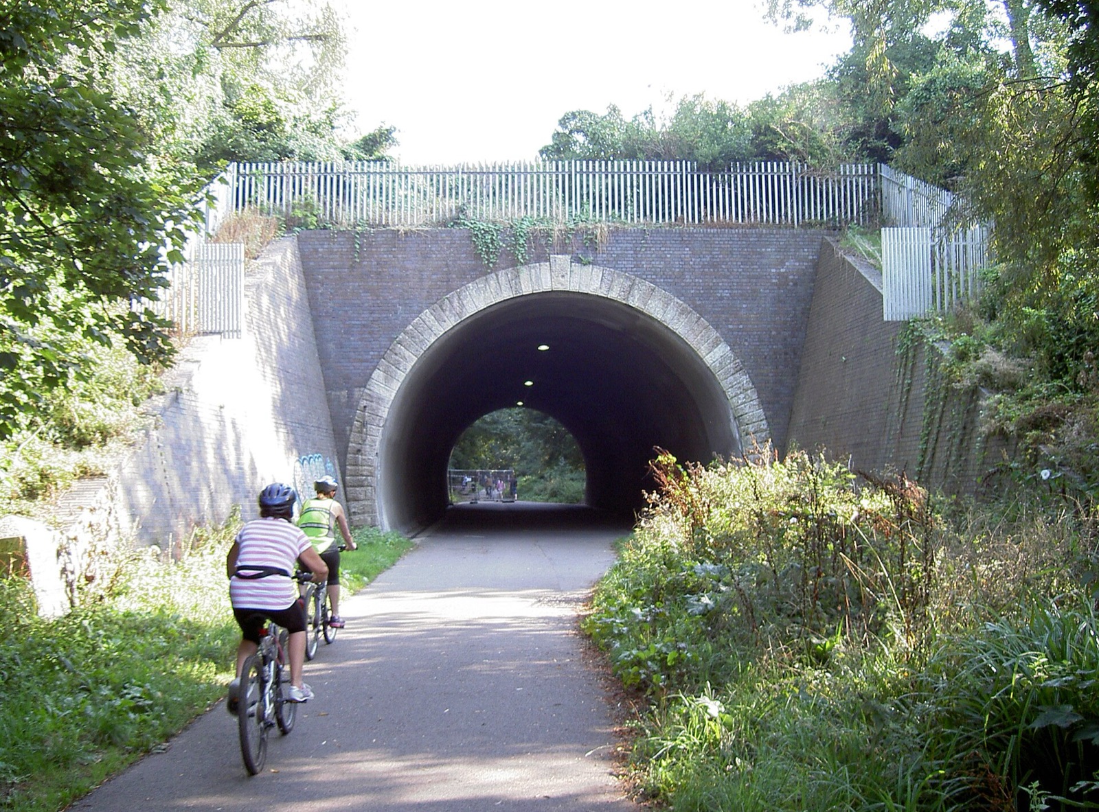 Cyclists on the Rodwell Trail passing through an old railway tunnel