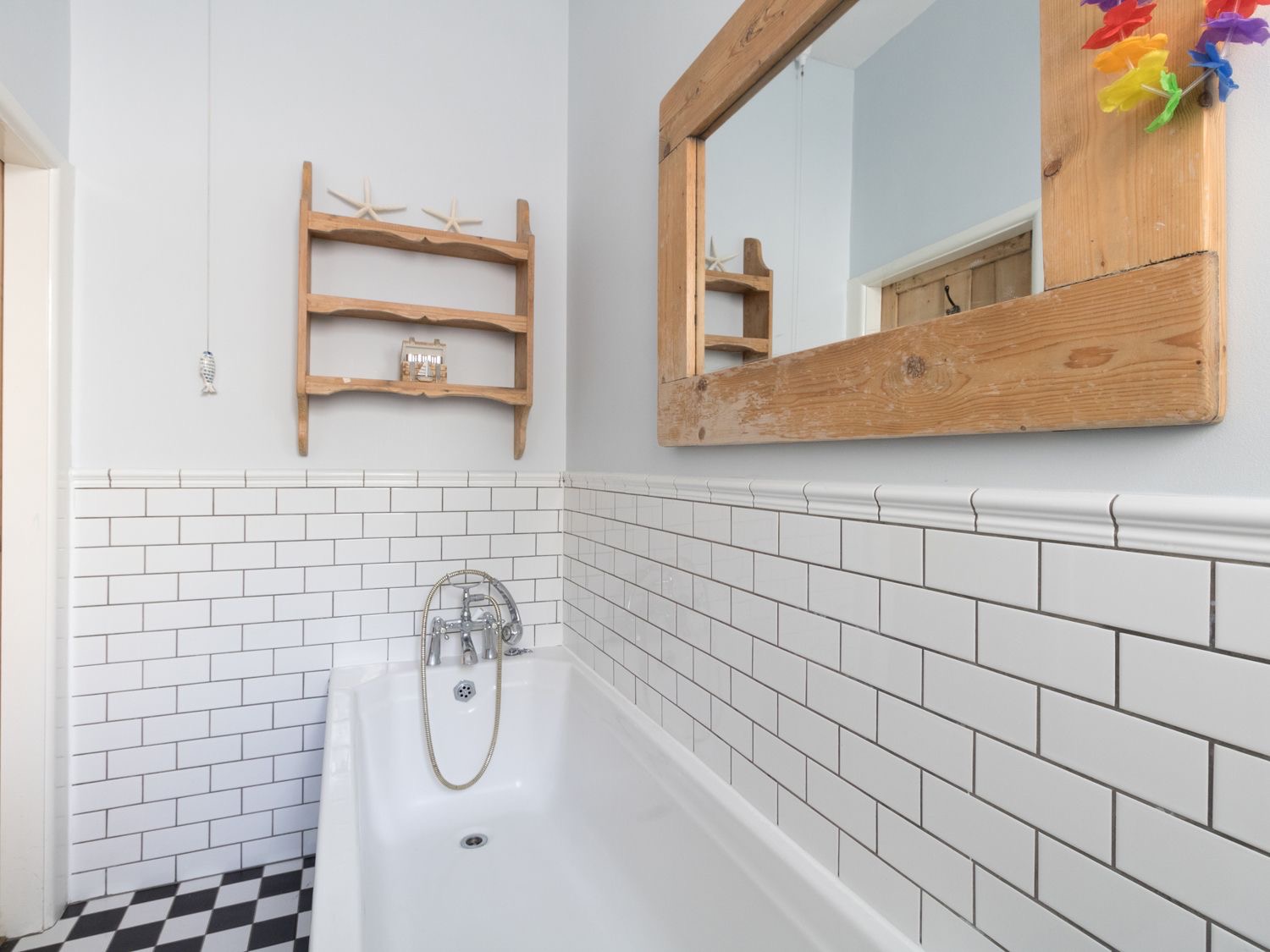 Sailor's Watch bathroom with a bath, white metro tiles and chequered floor