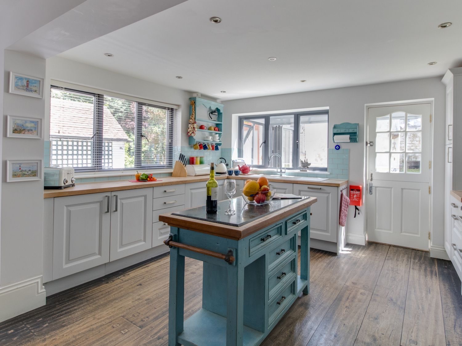 Sailor's Watch kitchen with white cabinets, blue island and range cooker