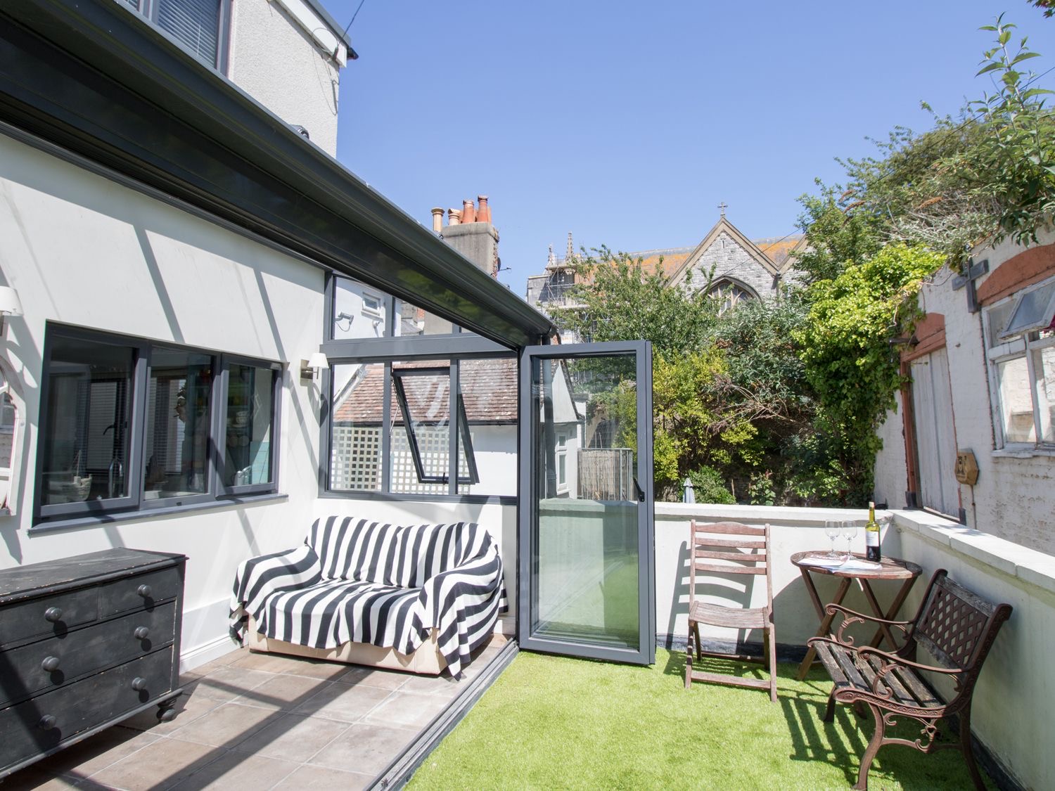 Sailor's Watch sun room with striped sofa and the terrace beyond