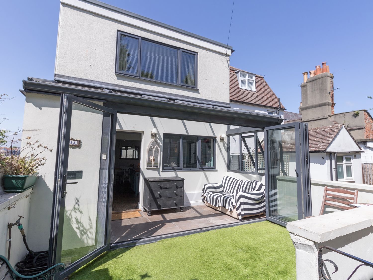 The sun room at Sailor's Watch with folding glass doors open onto the terrace
