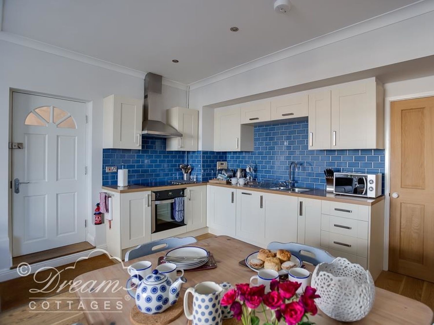 Waterside kitchen with cream units and cobalt-blue tiles