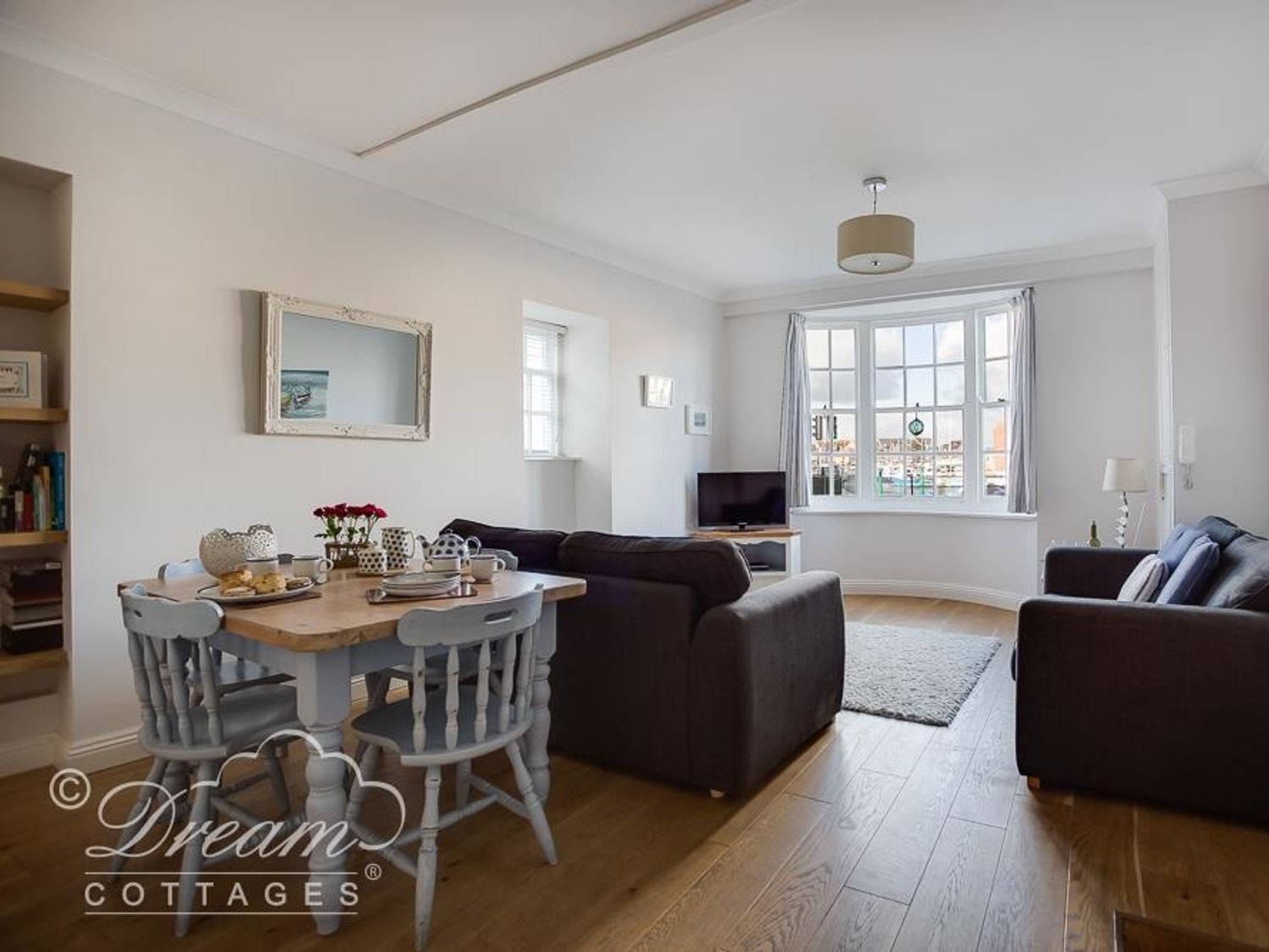 Waterside living and dining room with the bay window onto the harbour